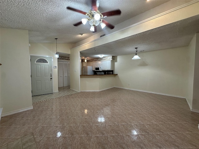 unfurnished living room with ceiling fan, vaulted ceiling, a textured ceiling, and light tile patterned flooring