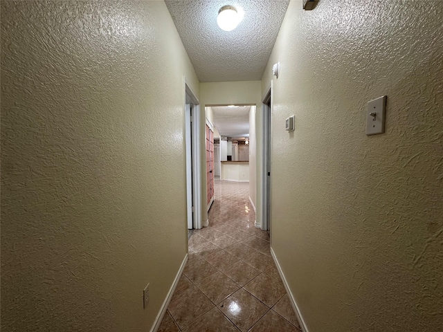 corridor featuring a textured ceiling and tile patterned flooring