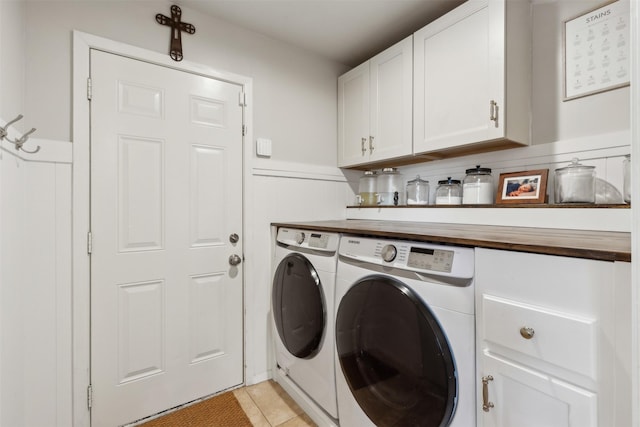 laundry room featuring independent washer and dryer, cabinets, and light tile patterned flooring