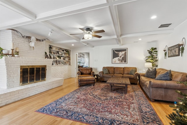 living room featuring built in features, coffered ceiling, and beam ceiling