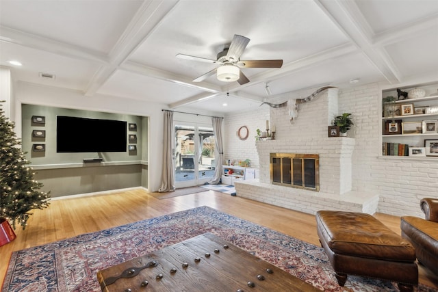 living room featuring a fireplace, coffered ceiling, and beam ceiling