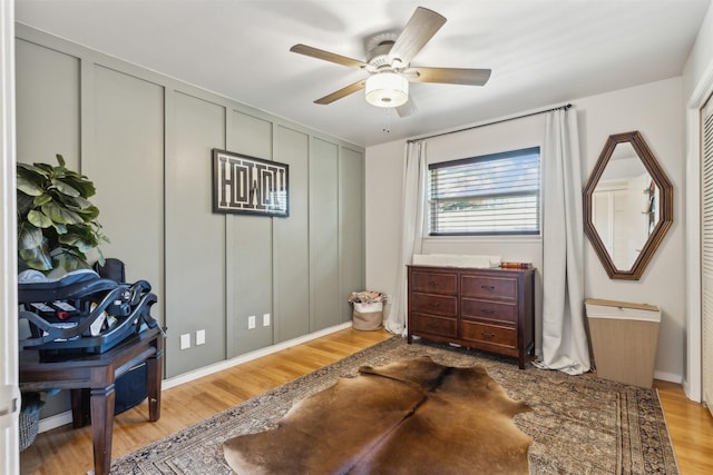 living area with light hardwood / wood-style floors and ceiling fan