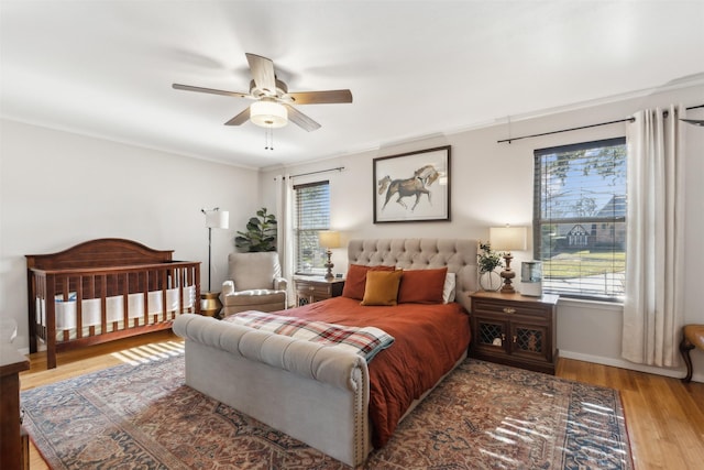 bedroom with light wood-type flooring, ceiling fan, and ornamental molding