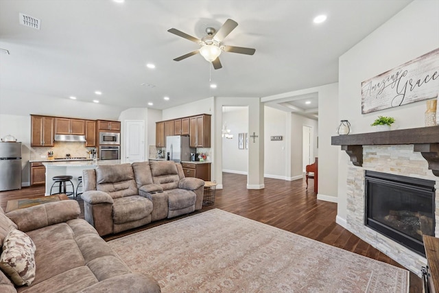 living room with a fireplace, ceiling fan, and dark hardwood / wood-style flooring