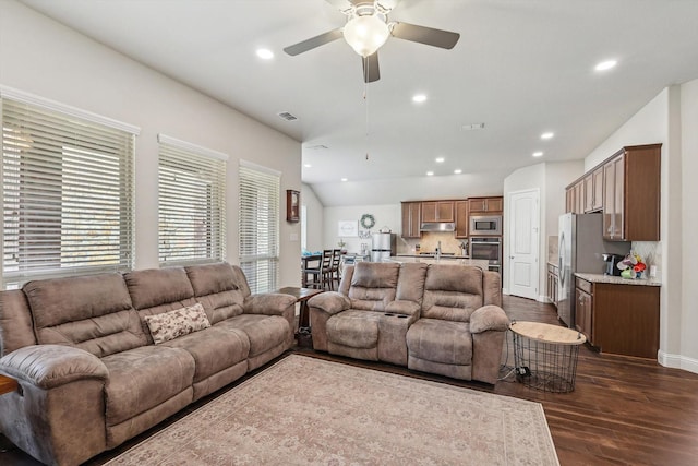 living room with ceiling fan, dark wood-type flooring, and lofted ceiling