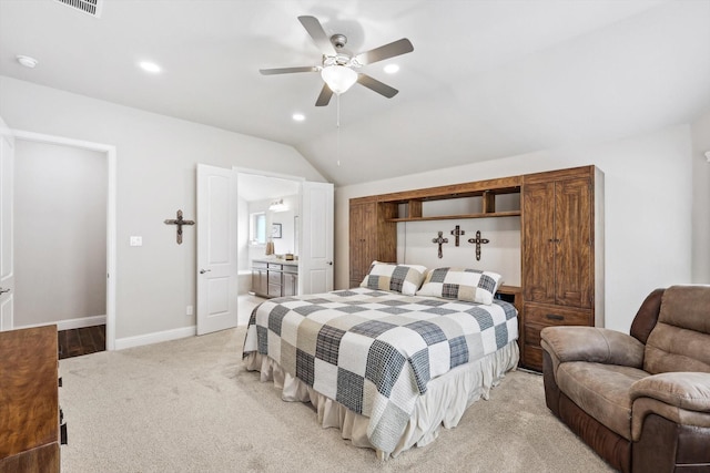 bedroom featuring ceiling fan, light colored carpet, connected bathroom, and vaulted ceiling