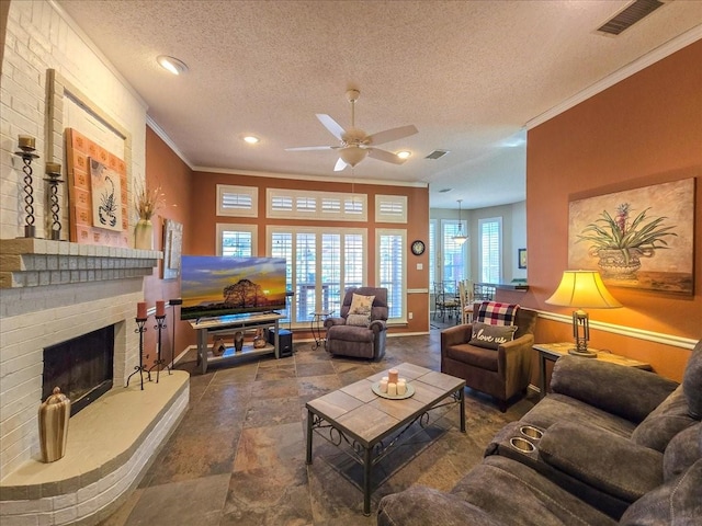 living room with a brick fireplace, a textured ceiling, crown molding, and ceiling fan