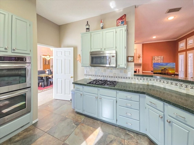 kitchen featuring kitchen peninsula, decorative backsplash, and appliances with stainless steel finishes