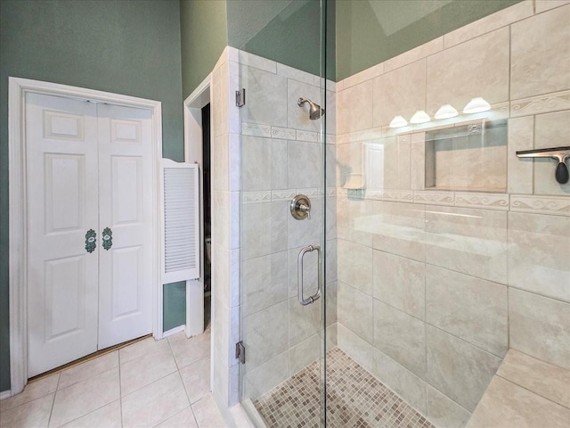 bathroom featuring a shower with shower door and tile patterned floors