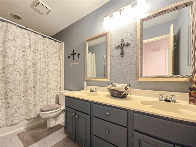 bathroom with curtained shower, hardwood / wood-style flooring, a textured ceiling, toilet, and vanity