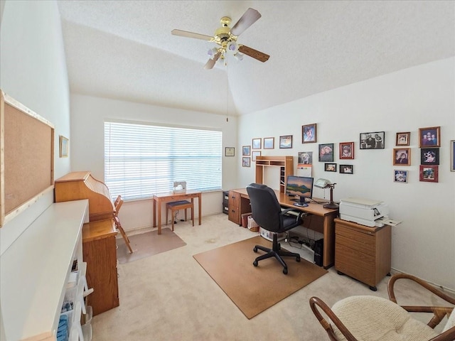 office space with vaulted ceiling, ceiling fan, light colored carpet, and a textured ceiling