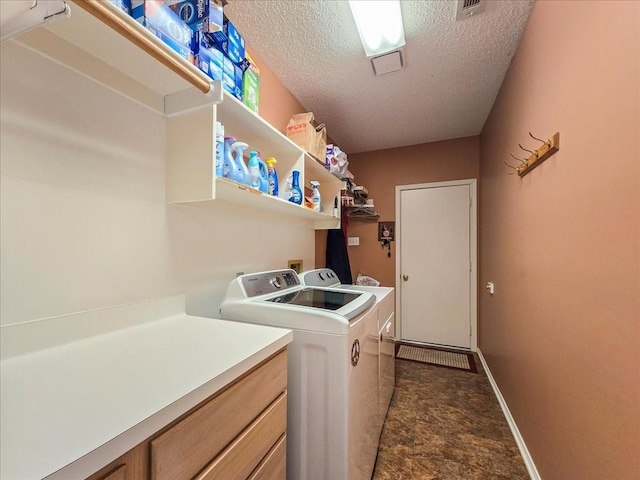 clothes washing area with a textured ceiling and separate washer and dryer