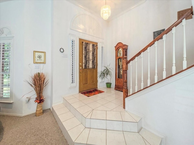 entrance foyer with a chandelier, light tile patterned floors, and ornamental molding