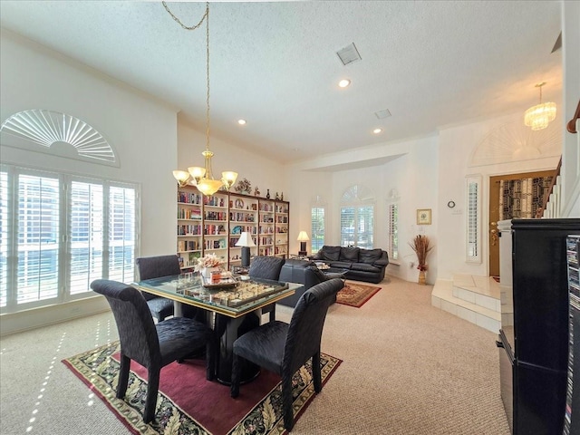 dining room with a chandelier, carpet flooring, and a textured ceiling