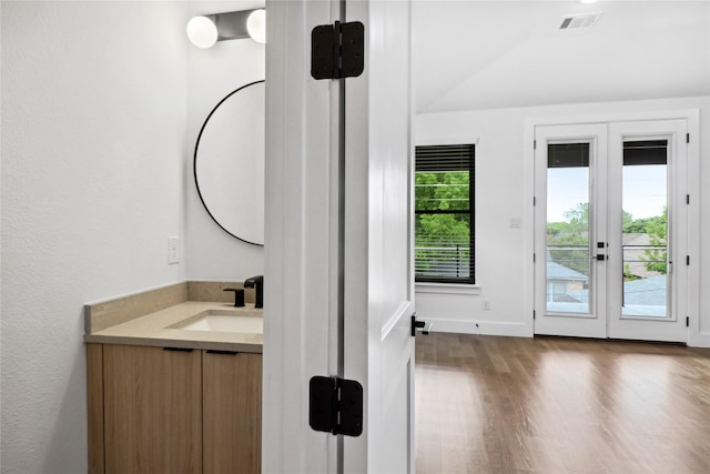 bathroom featuring vanity, lofted ceiling, and french doors