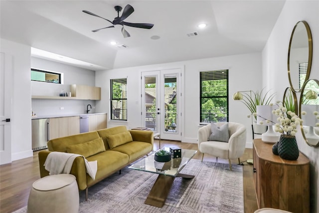 living room with vaulted ceiling, french doors, ceiling fan, and wood-type flooring