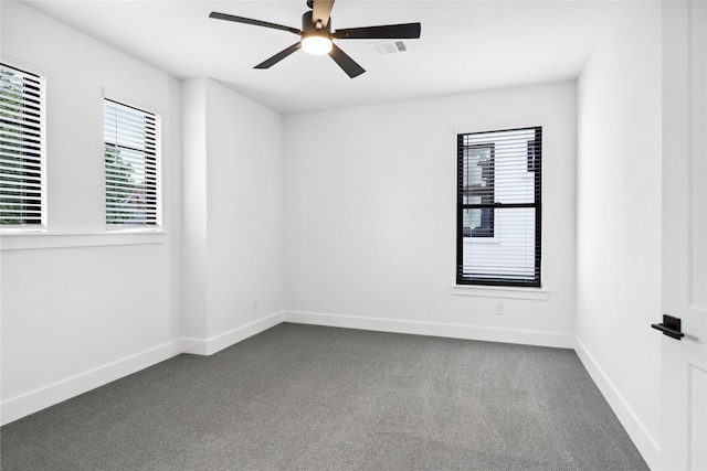 empty room featuring dark colored carpet and ceiling fan