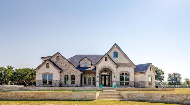 french country style house with a front yard and french doors