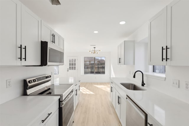 kitchen featuring light hardwood / wood-style floors, sink, white cabinets, and appliances with stainless steel finishes