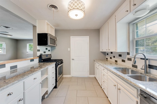 kitchen with white cabinets, stainless steel appliances, backsplash, and sink