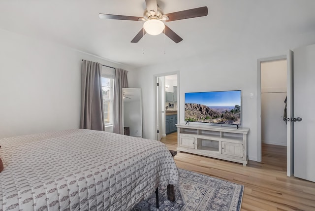 bedroom with light hardwood / wood-style floors, connected bathroom, and ceiling fan