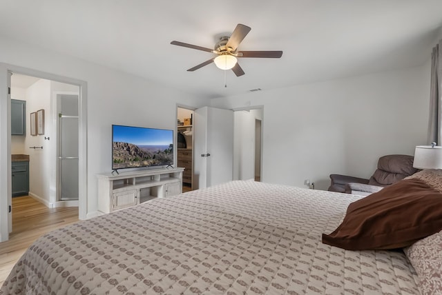 bedroom featuring light wood-type flooring, ceiling fan, and a walk in closet