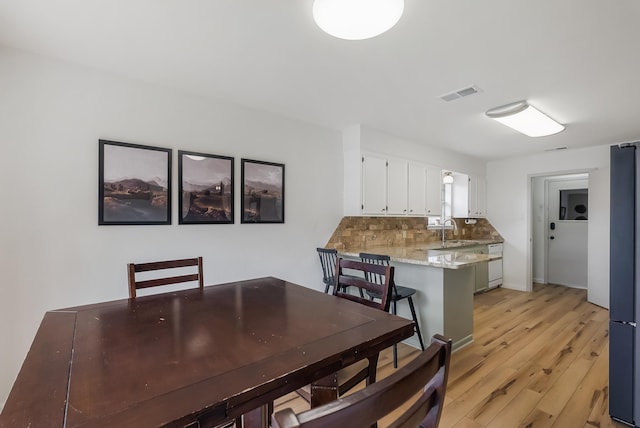 dining space featuring sink and light wood-type flooring