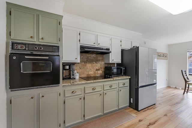 kitchen featuring black appliances, tasteful backsplash, light hardwood / wood-style flooring, and light stone countertops