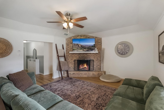 living room featuring a fireplace, hardwood / wood-style floors, vaulted ceiling, and ceiling fan