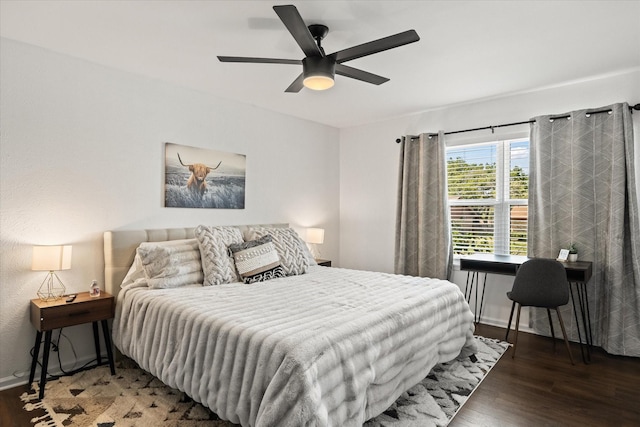 bedroom with a ceiling fan, baseboards, and wood finished floors