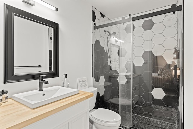 bathroom featuring toilet, a shower stall, and vanity