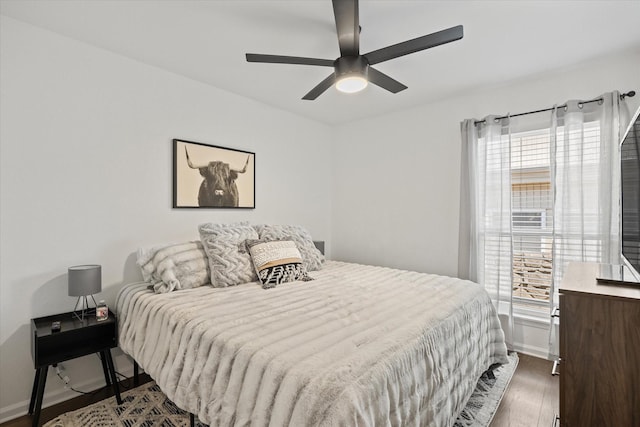 bedroom with a ceiling fan, baseboards, and wood finished floors