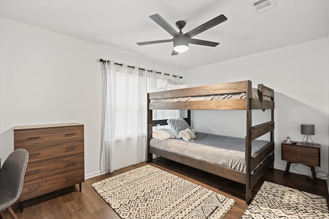 bedroom with baseboards, ceiling fan, visible vents, and wood finished floors