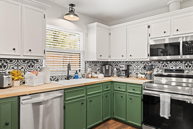 kitchen featuring stainless steel appliances, white cabinetry, a sink, and decorative backsplash