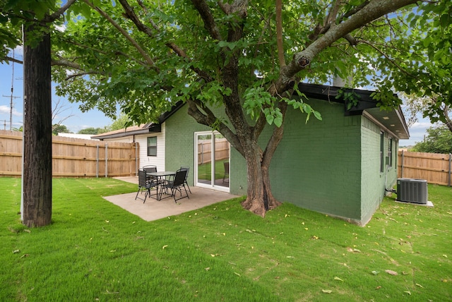 rear view of property featuring brick siding, central air condition unit, a patio area, and fence