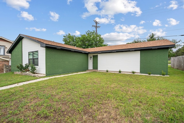 view of front of property featuring a front lawn, fence, and brick siding