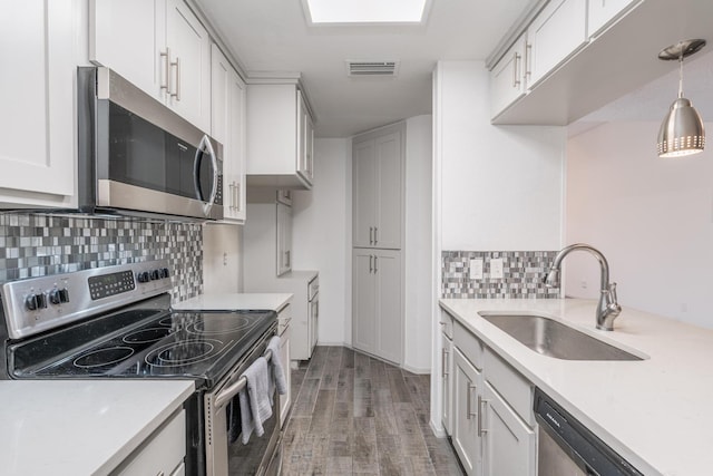 kitchen with decorative light fixtures, white cabinetry, decorative backsplash, and stainless steel appliances