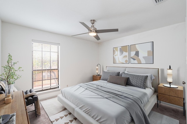 carpeted bedroom featuring ceiling fan and multiple windows