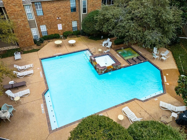 view of swimming pool featuring a patio area and a hot tub