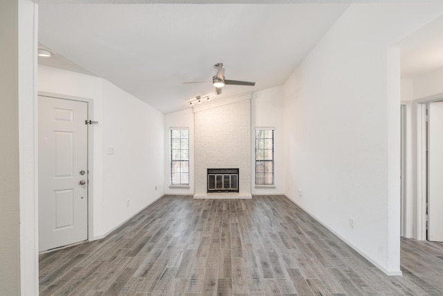 unfurnished living room with a fireplace, light hardwood / wood-style floors, vaulted ceiling, and ceiling fan