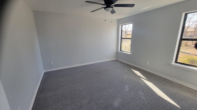 empty room featuring dark carpet and ceiling fan