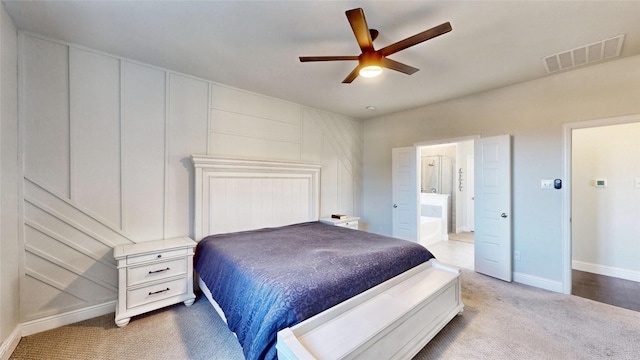 bedroom featuring ceiling fan, connected bathroom, and light carpet