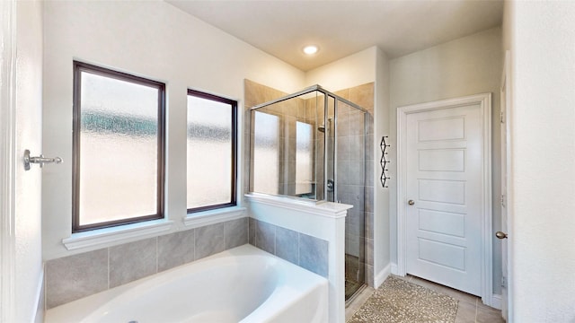 bathroom featuring a wealth of natural light, separate shower and tub, and tile patterned flooring