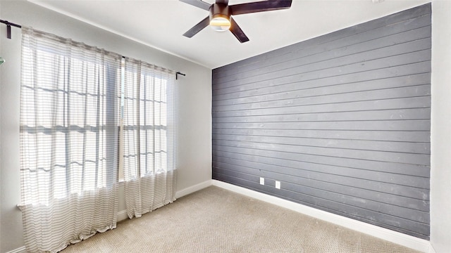 carpeted spare room featuring ceiling fan