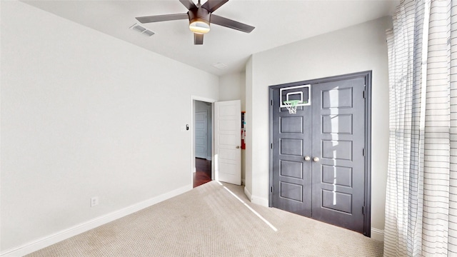 unfurnished bedroom featuring ceiling fan and carpet