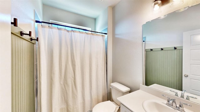 bathroom with toilet, vanity, and a shower with shower curtain