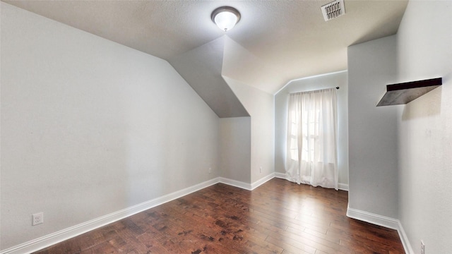 bonus room featuring vaulted ceiling and dark hardwood / wood-style floors