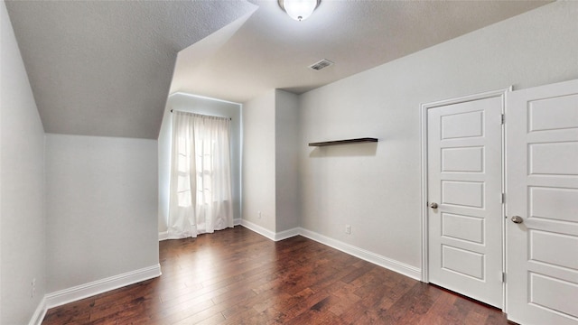 interior space featuring a closet, dark wood-type flooring, and lofted ceiling