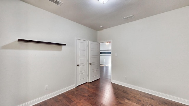 unfurnished bedroom with dark hardwood / wood-style floors