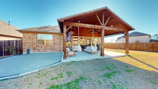 back of house with a patio area, a yard, and ceiling fan